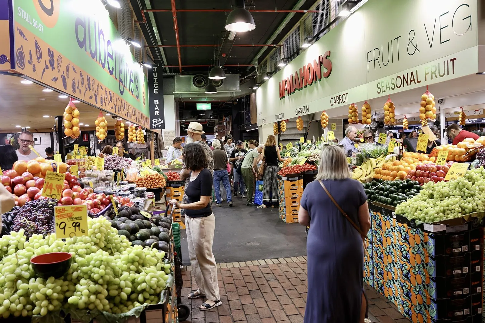Shoppers browsing the fruit and veg stalls at Adelaide Central Market