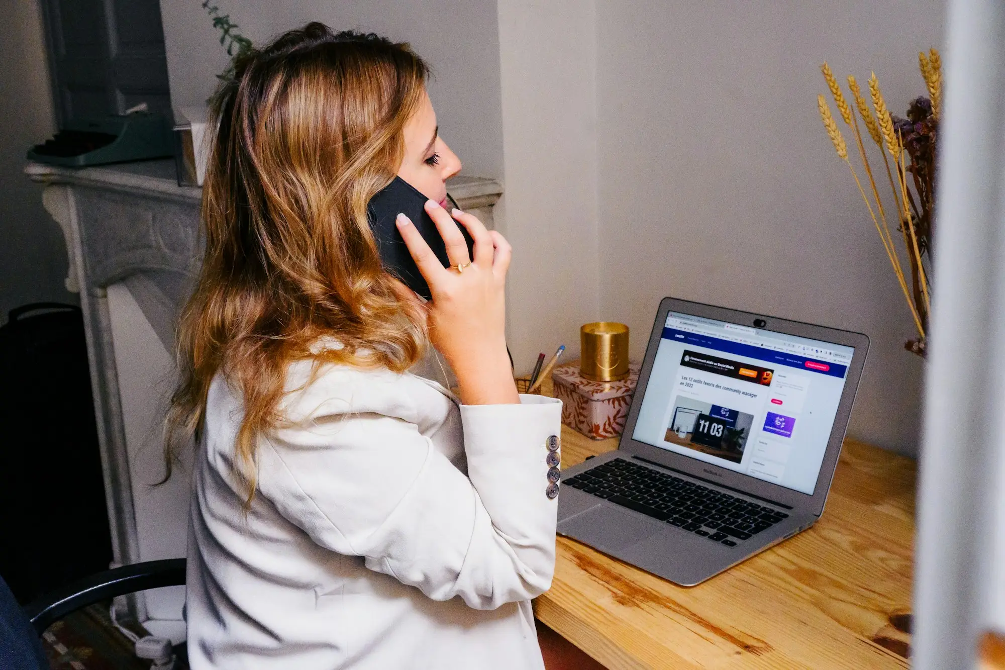 Business owner at her desk with a laptop and phone, planning the week